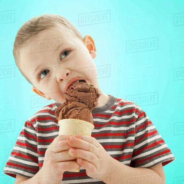 Caucasian boy eating ice cream cone Stock Photo Dissolve