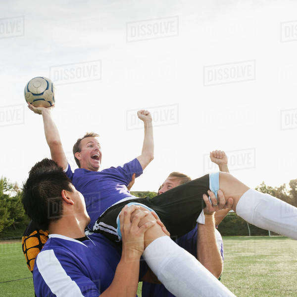 soccer-players-lifting-teammate-and-cheering-stock-photo-dissolve