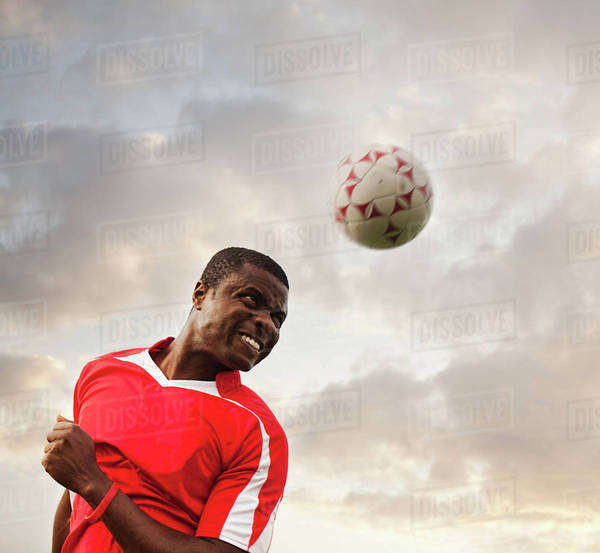 Black soccer player heading the ball Stock Photo Dissolve