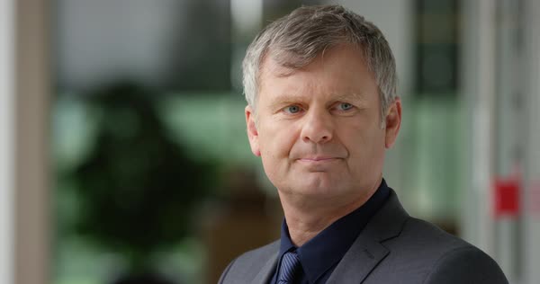 Grey Haired Man In Suit Nods Approvingly Before Walking Away