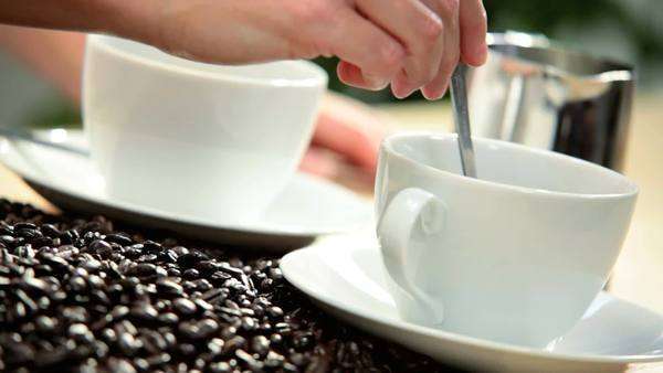 Cups Of Aromatic Fresh Ground Coffee With Milk White Table Close Up Female Caucasian Hands Stirring Freshly Made Coffee White Cups Saucers Next To Whole