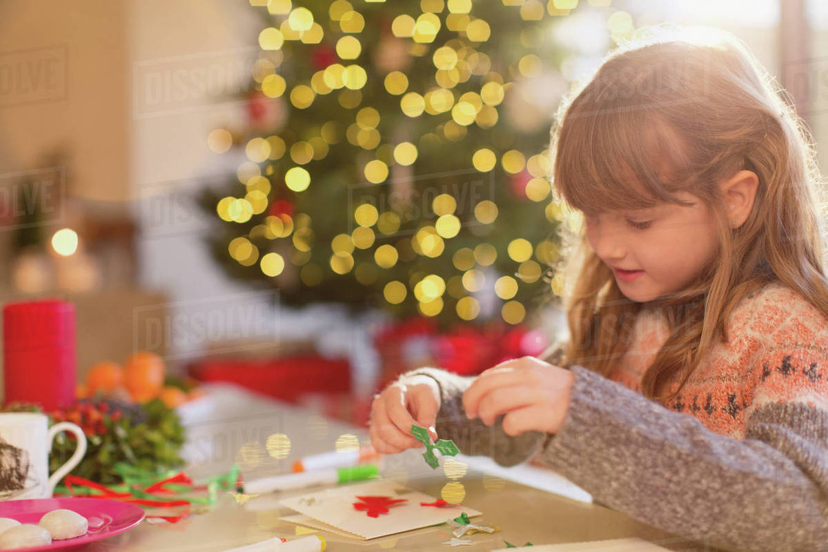 Girl making Christmas decorations at table Royalty-free stock photo