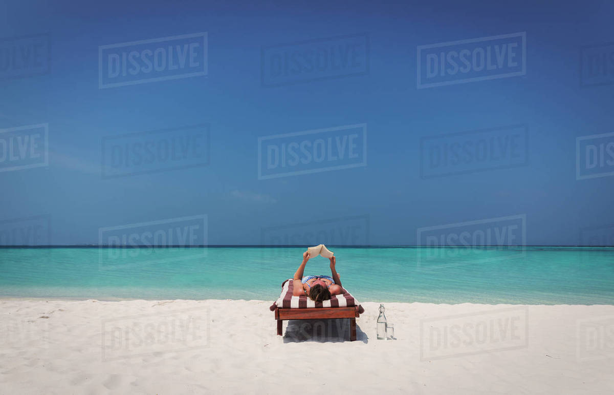 Woman Relaxing Laying And Reading Book On Lounge Chair Sunny Woman Relaxing Laying And Reading Book On Lounge Chair Sunny Tropical Beach
