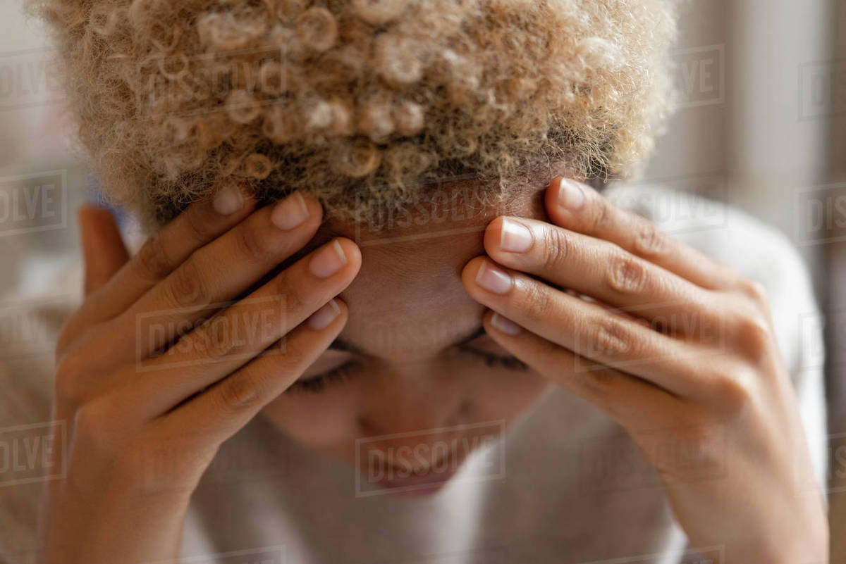 Woman with headache rubbing forehead Stock Photo Dissolve