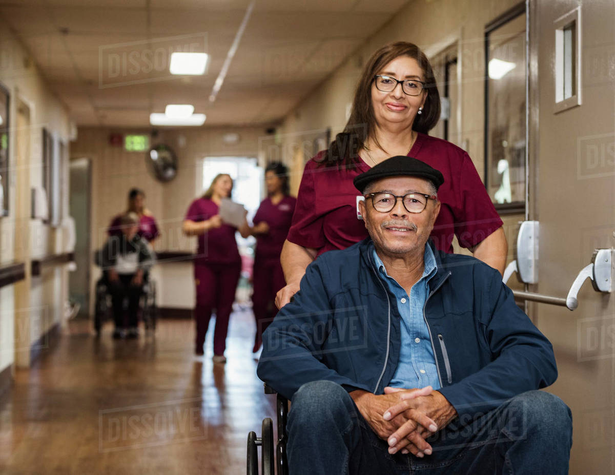 Nurse assisting senior man in wheelchair Royalty-free stock photo