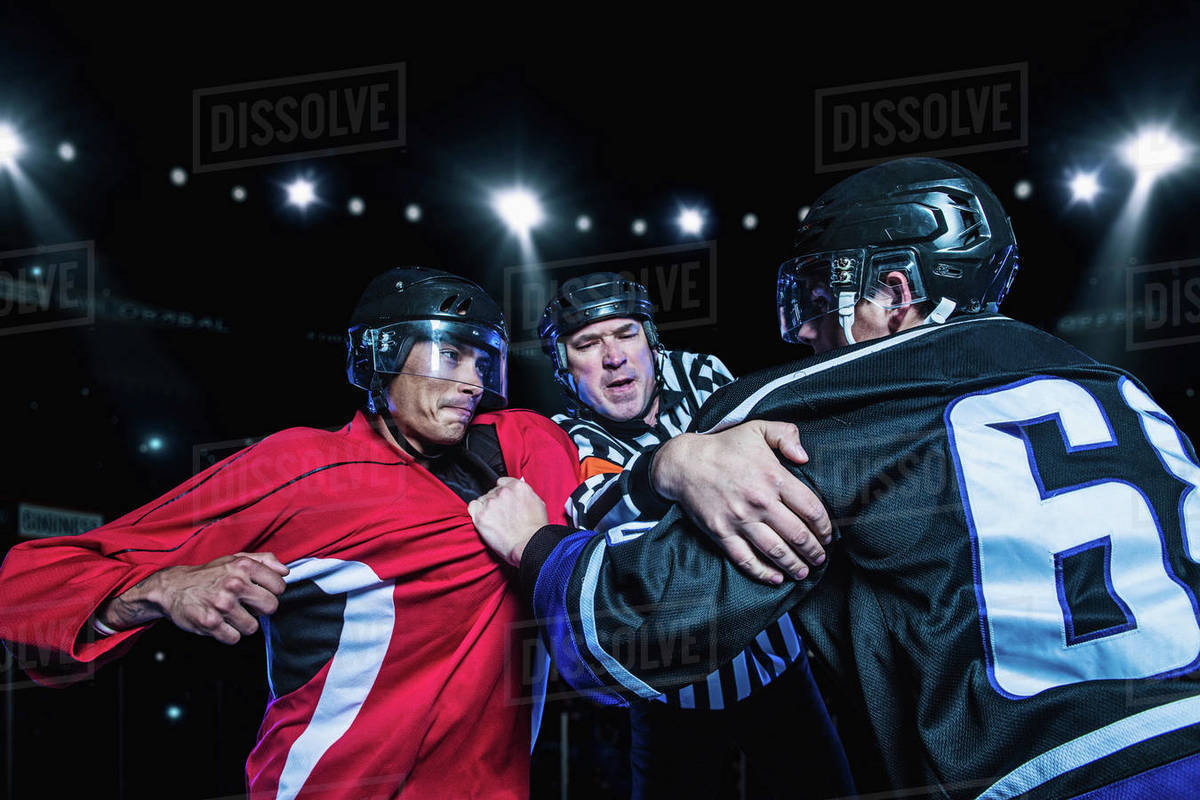 Referee separating fighting hockey players Stock Photo Dissolve