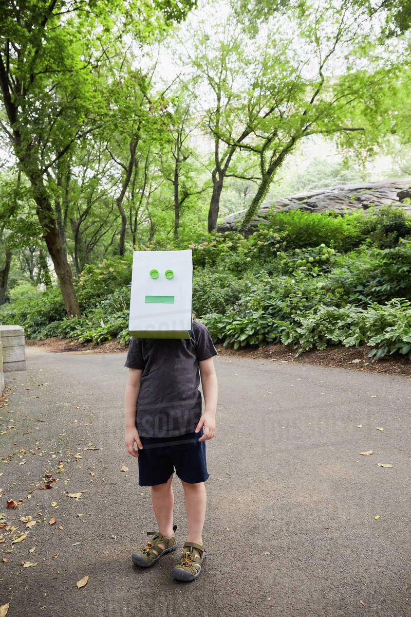 Girl (23) wearing robot mask in park Stock Photo Dissolve