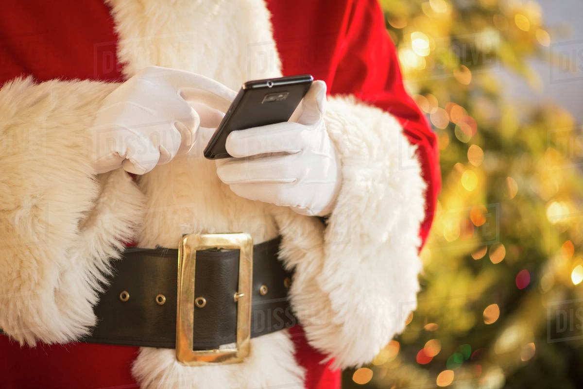 Santa claus holding cell phone Stock Photo Dissolve