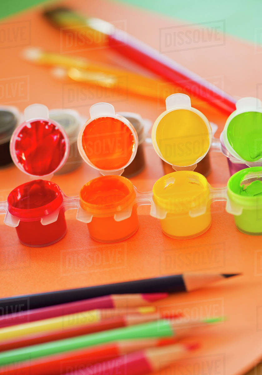 Close up of watercolor paints, crayons and paintbrushes, studio shot Stock Photo Dissolve