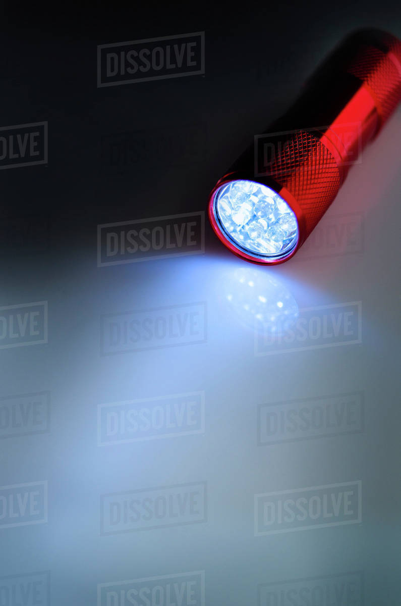 Illuminated flashlight Stock Photo Dissolve