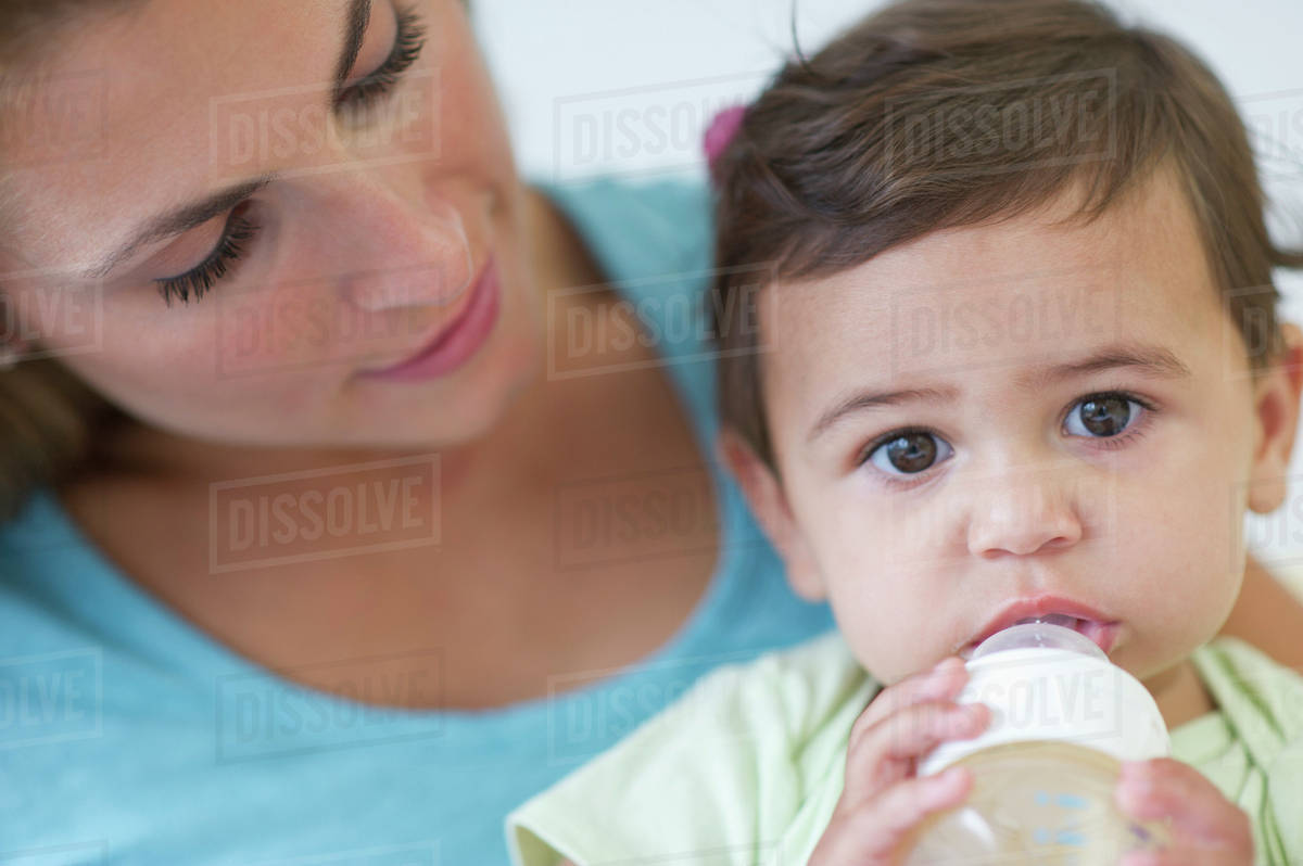 Mother feeding baby daughter (1218 months) Stock Photo Dissolve