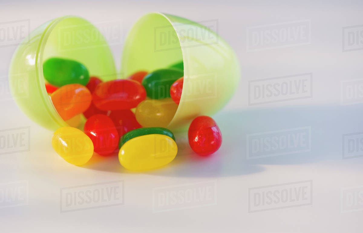 Jelly beans in a plastic Easter egg Stock Photo Dissolve