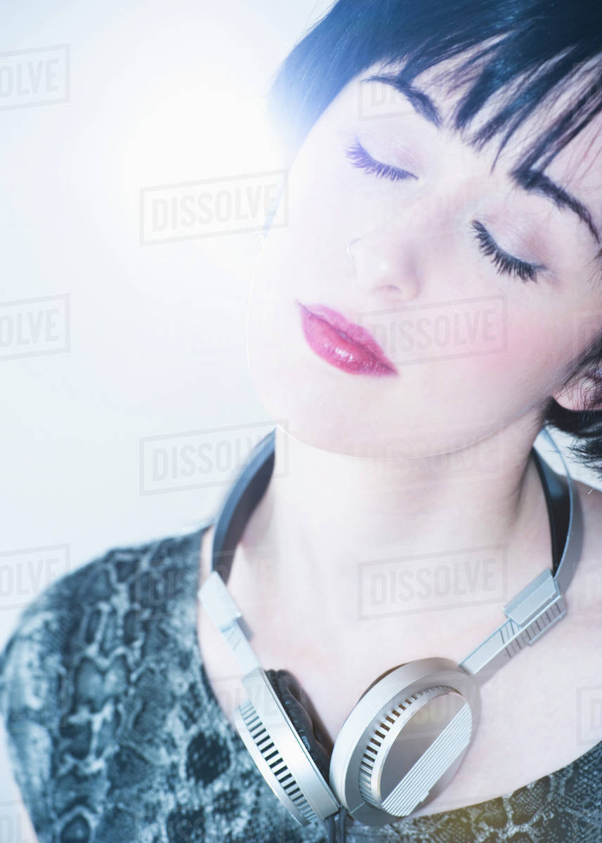 Relaxed woman with headphones around her neck Stock Photo Dissolve