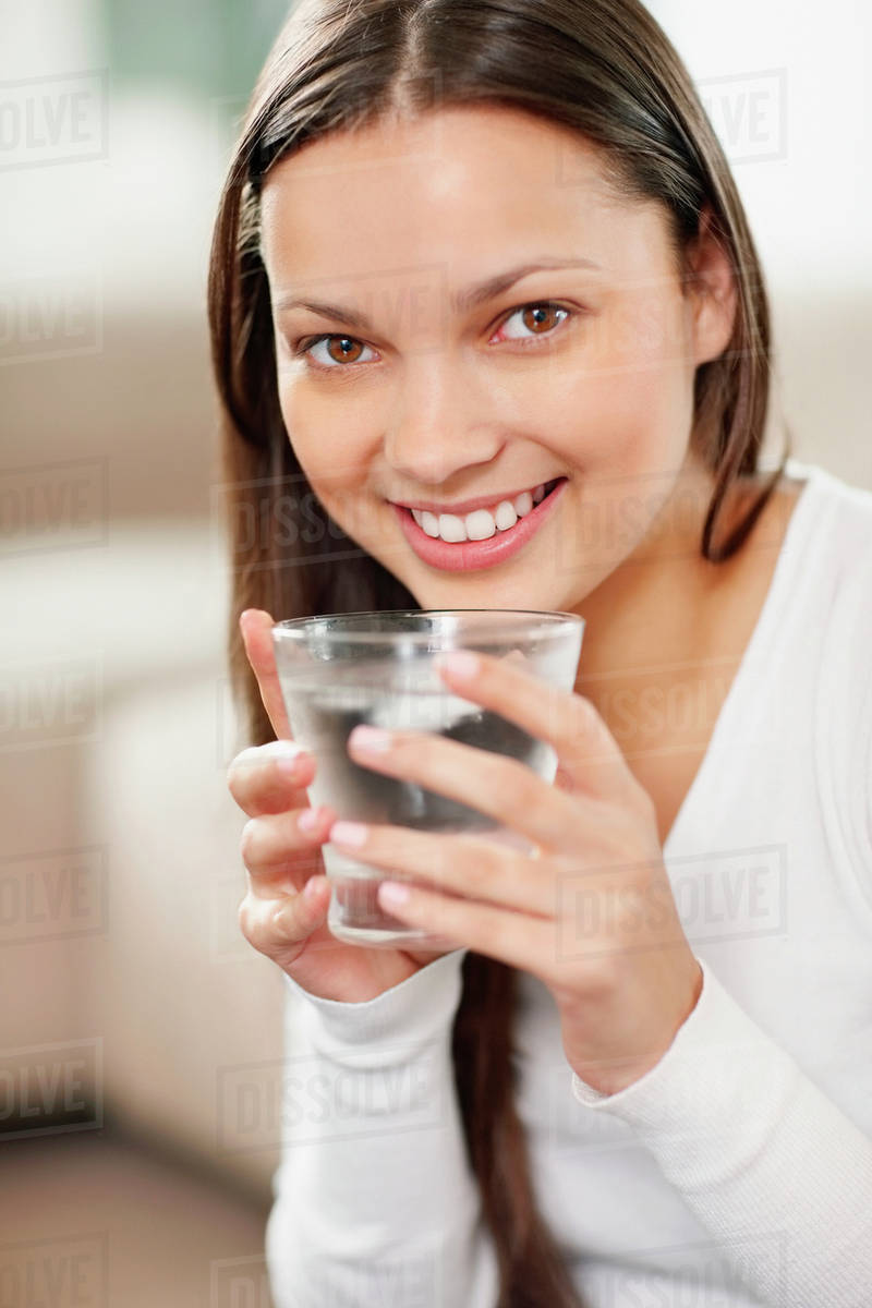 Woman drinking a glass of water Stock Photo Dissolve