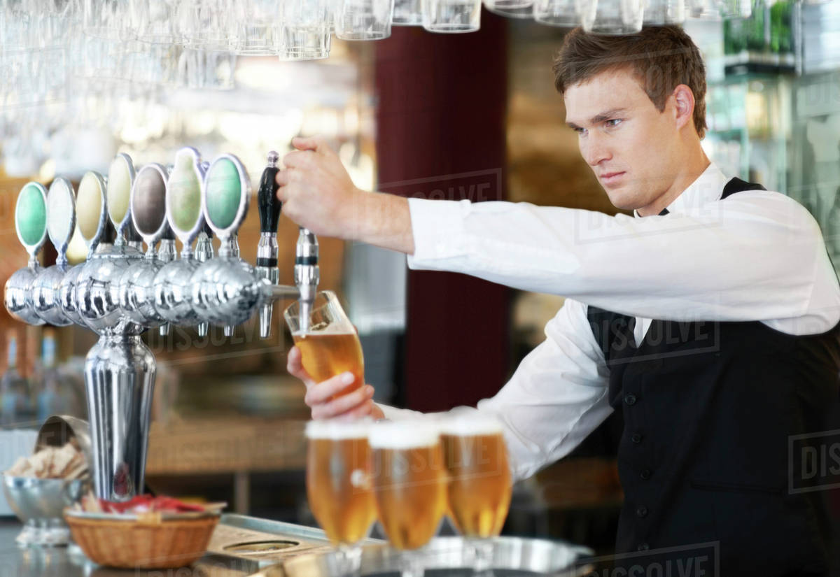 Bartender pouring beer Stock Photo Dissolve