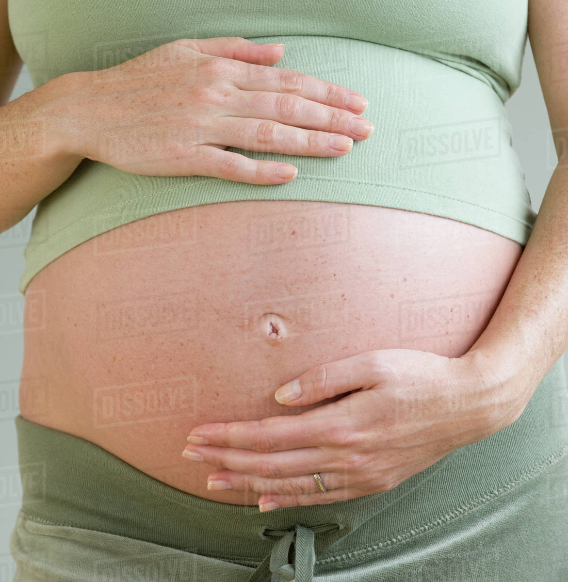 Pregnant woman with hands on belly Stock Photo Dissolve