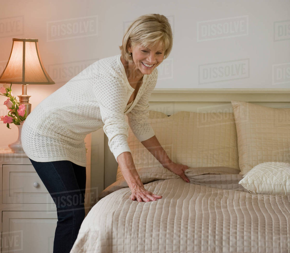 Woman making bed Stock Photo Dissolve