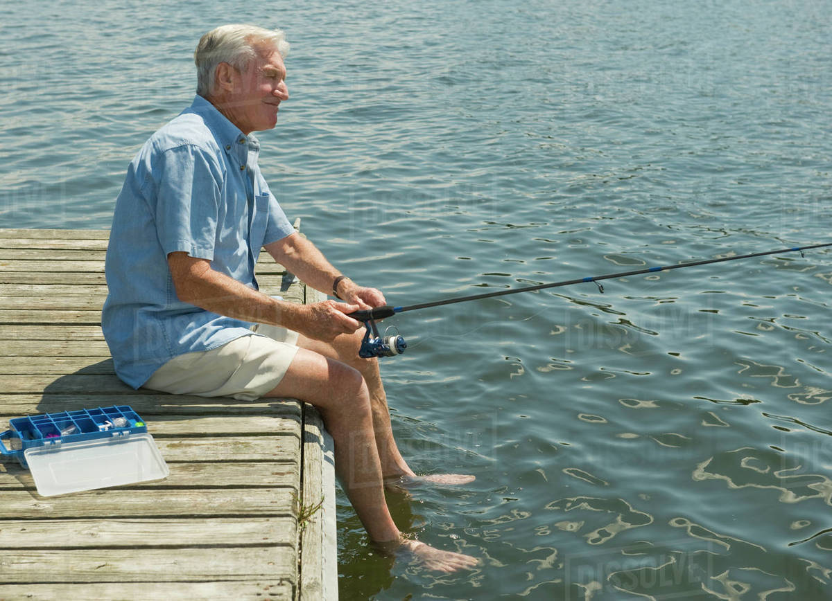 Senior man fishing off dock Stock Photo Dissolve