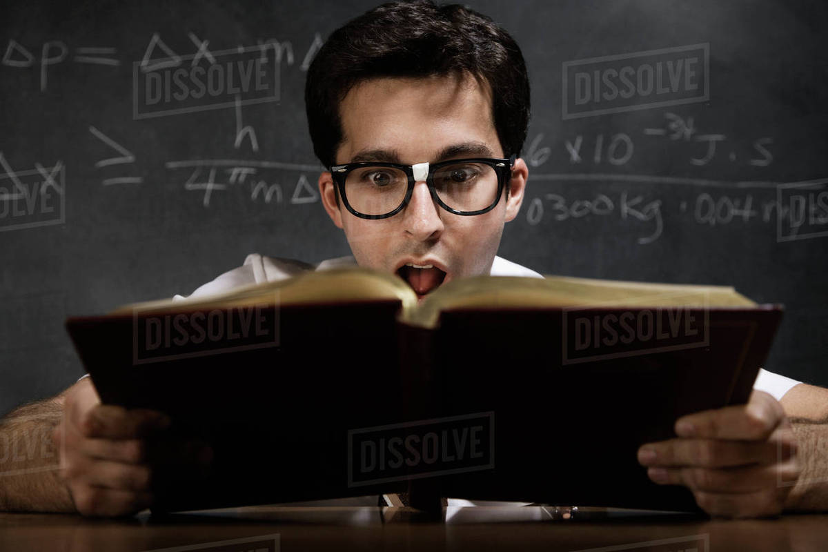 Nerdy man reading book Stock Photo Dissolve