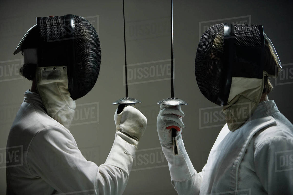 Fencers in masks facing off with fencing foils Stock Photo Dissolve