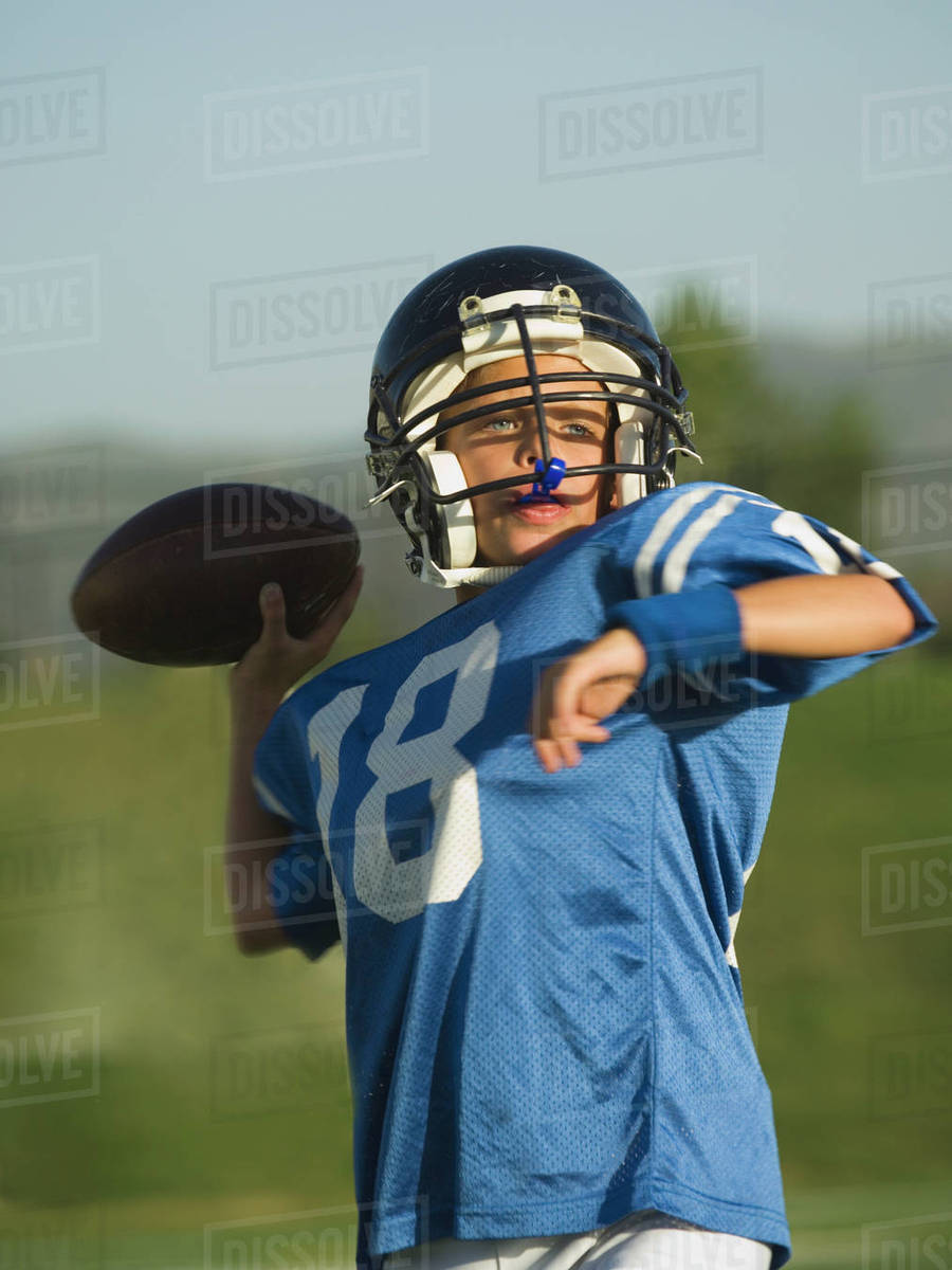 Young football player throwing ball Stock Photo Dissolve