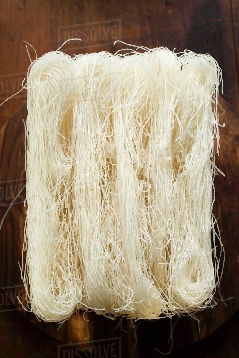 Thin rice noodles on wooden plate Stock Photo Dissolve
