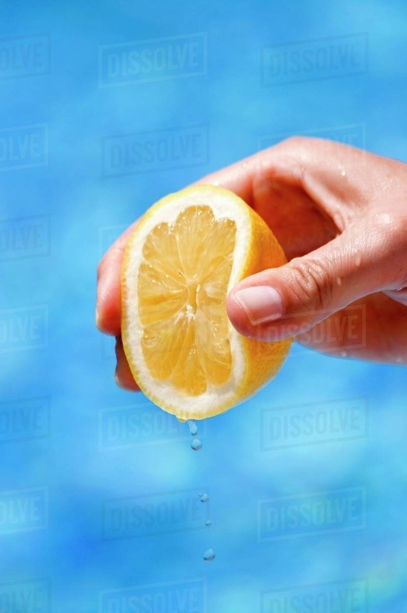 A hand squeezing a lemon Stock Photo Dissolve