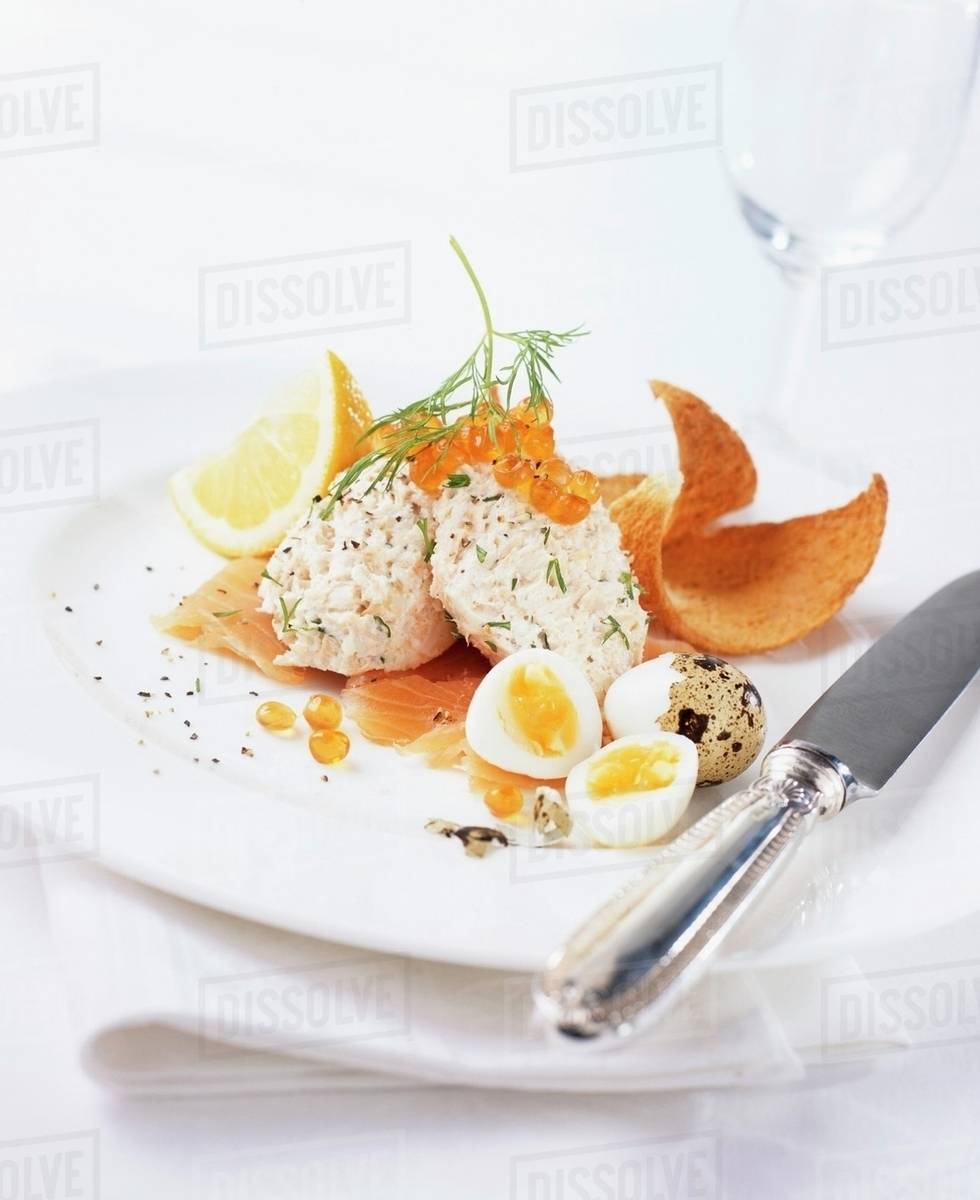 Smoked fish balls on smoked salmon with quails' eggs Stock Photo