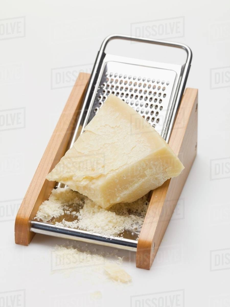 Parmesan on cheese grater Stock Photo Dissolve