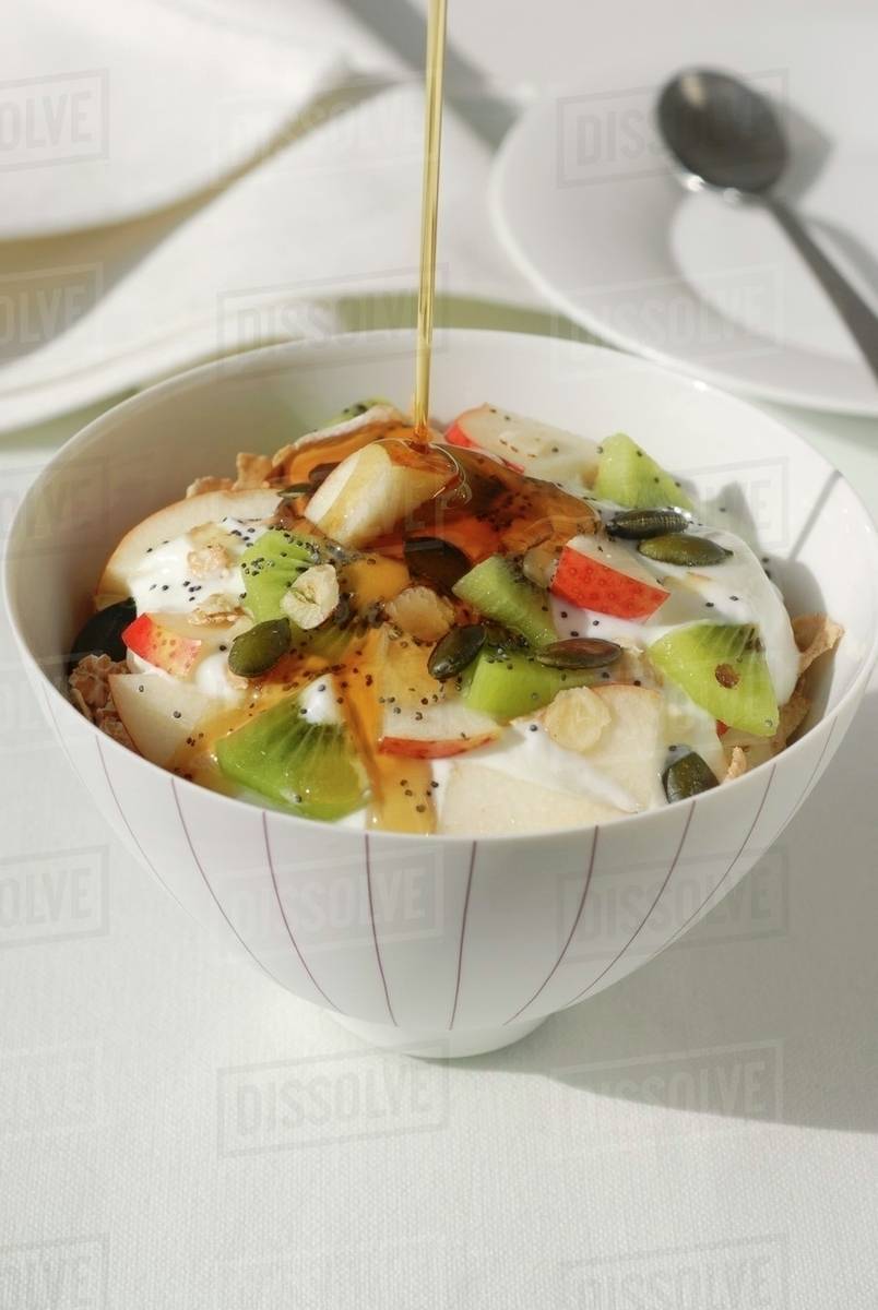 Muesli with yoghurt, fruit and honey Stock Photo Dissolve