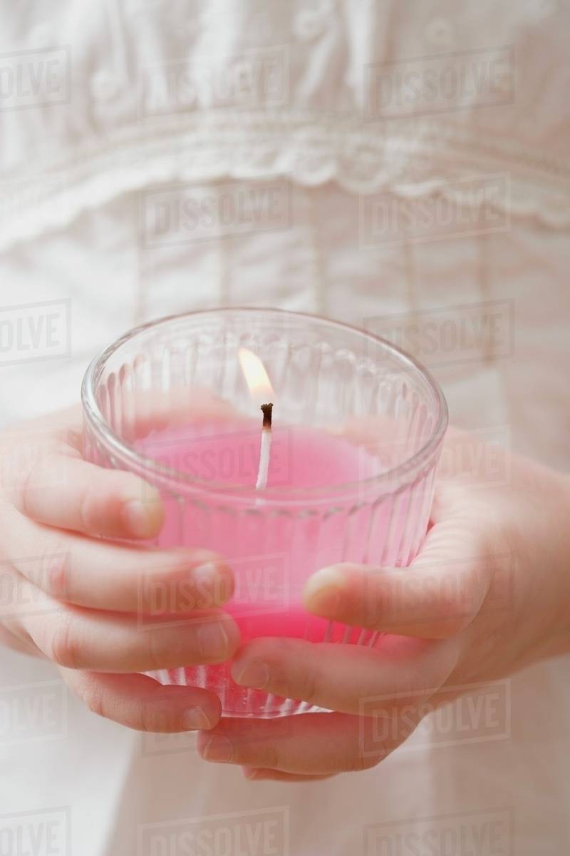 Girl holding burning scented candle Stock Photo Dissolve