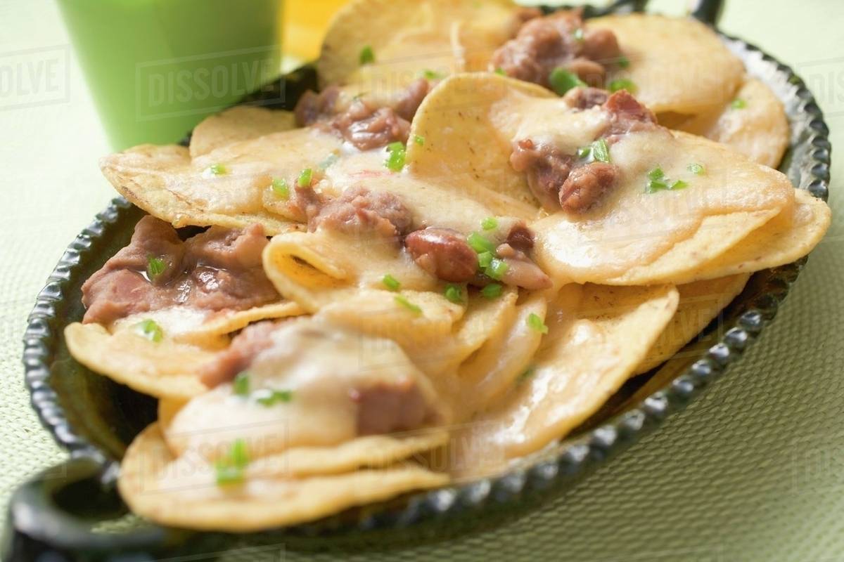 Tortilla chips with melted cheese and beans Stock Photo Dissolve