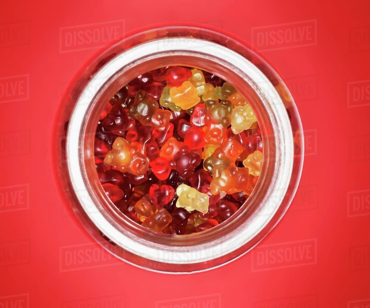 Gummi bears in storage jar (overhead view) - Stock Photo - Dissolve
