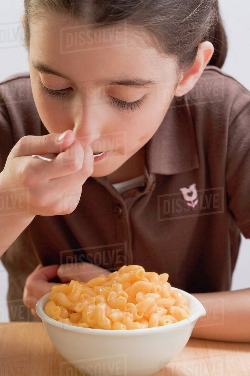Little girl eating macaroni cheese Stock Photo Dissolve