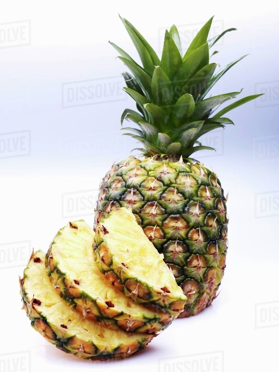 Pineapple slices and a whole pineapple Stock Photo Dissolve