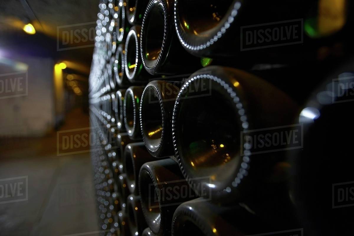 A closeup of bottle bottoms in an aisle of a wine cellar Stock Photo