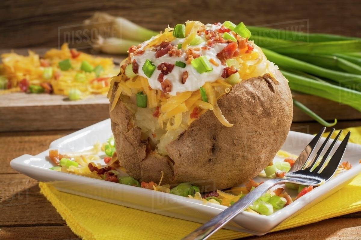 A twice baked potato with Cheddar cheese, onions, sour cream and