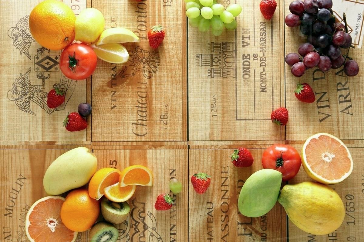 Various fruits and tomatoes on wine crates Stock Photo Dissolve