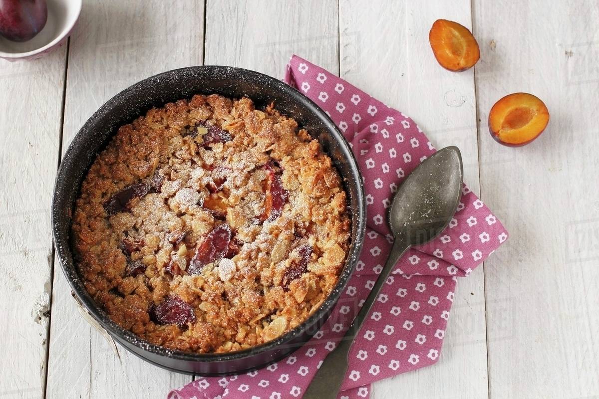 Plum crumble in baking dish Stock Photo Dissolve