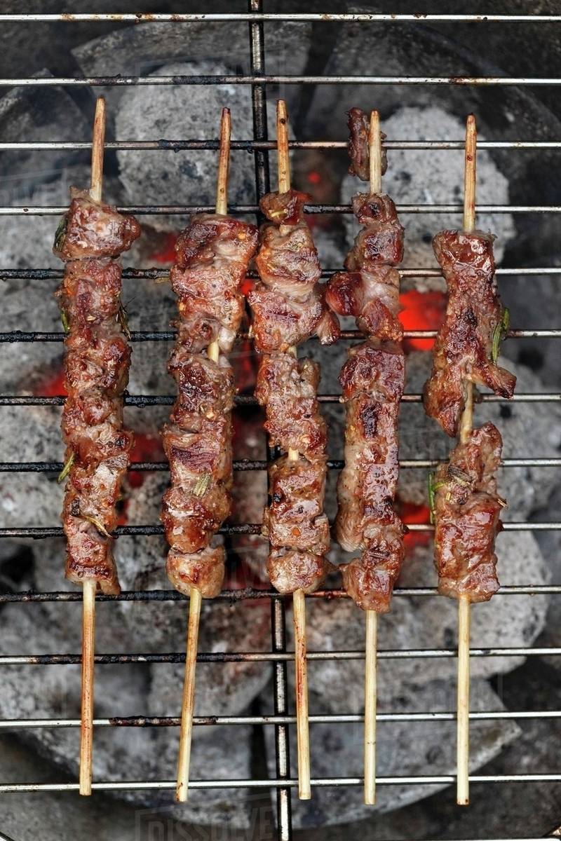 Lamb skewers on a barbecue (seen from above) Stock Photo Dissolve