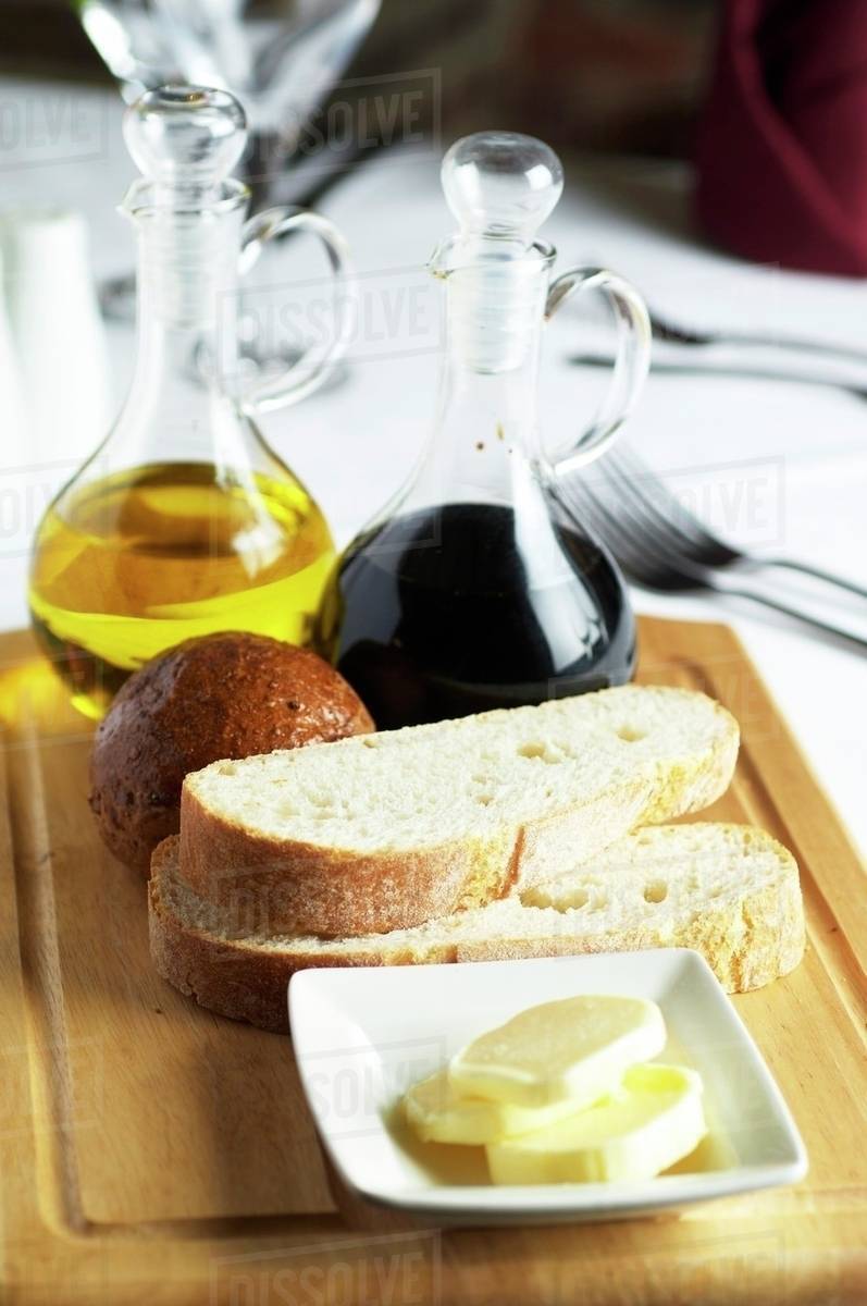 Balsamic vinegar, olive oil, bread and butter Stock Photo Dissolve
