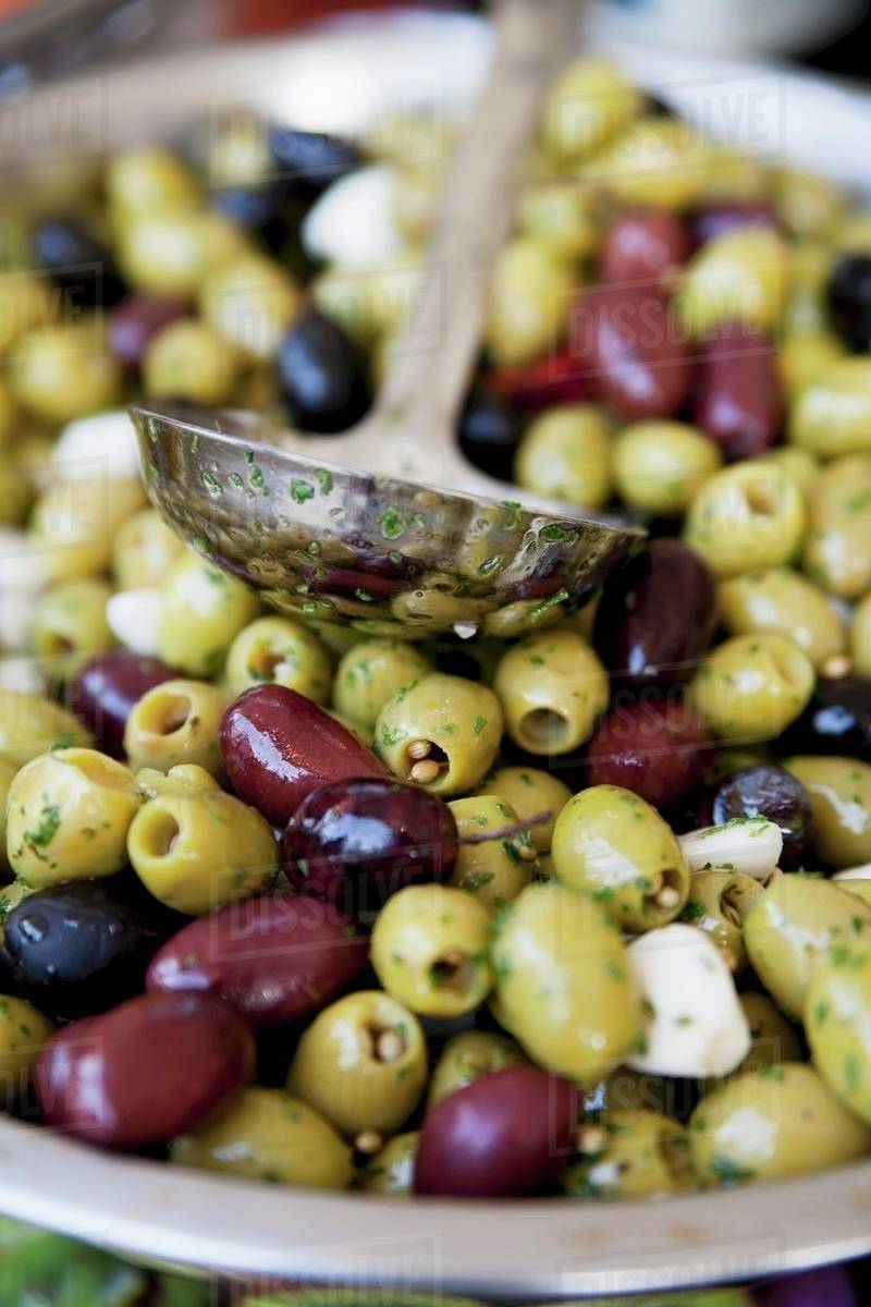 Pickled green and black olives with garlic and herbs Stock Photo