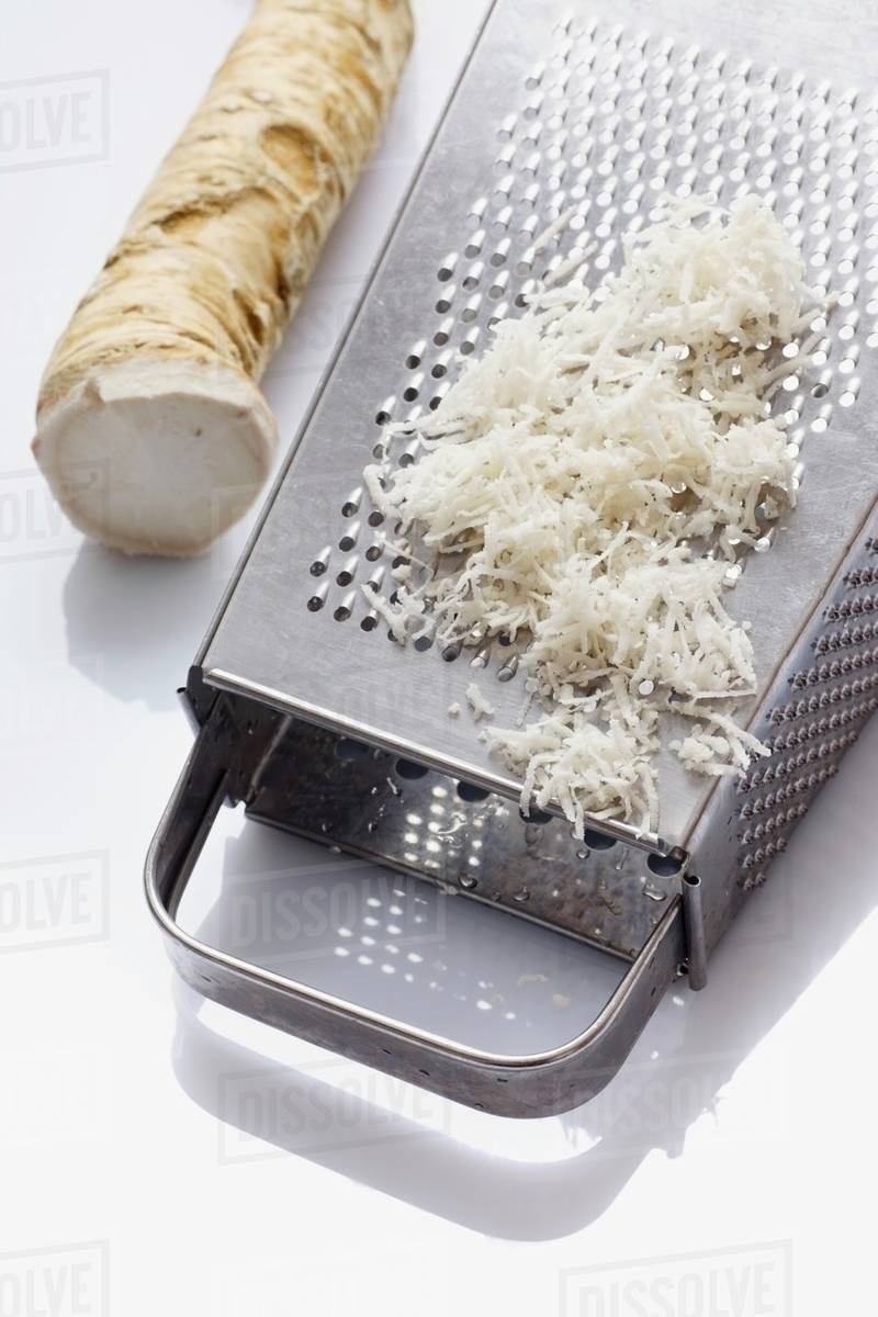 Horseradish, whole and grated with a grater Stock Photo Dissolve