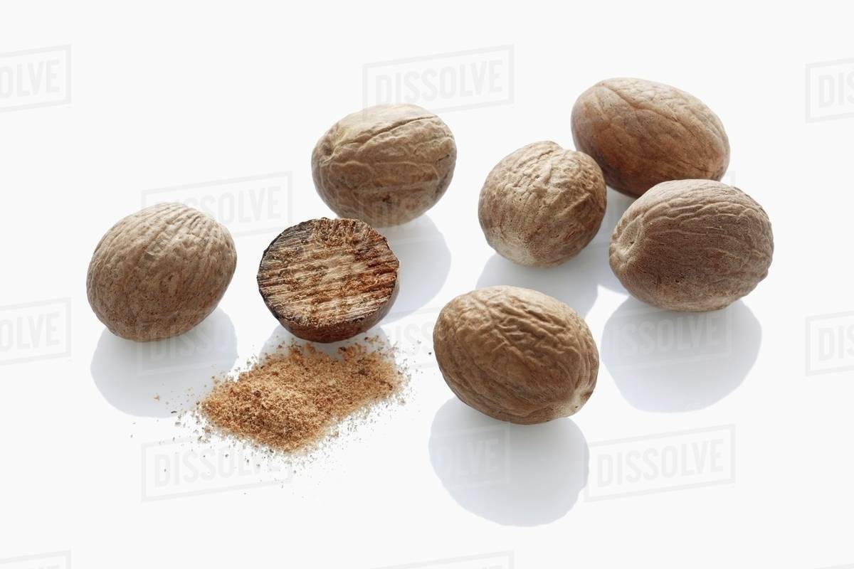 Whole nutmegs and ground nutmeg Stock Photo Dissolve