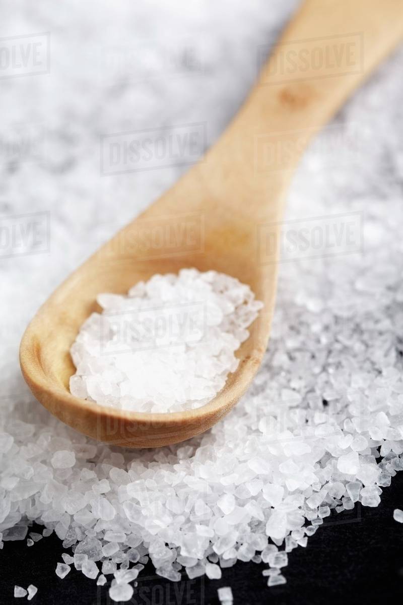 Coarse salt with a wooden spoon Stock Photo Dissolve