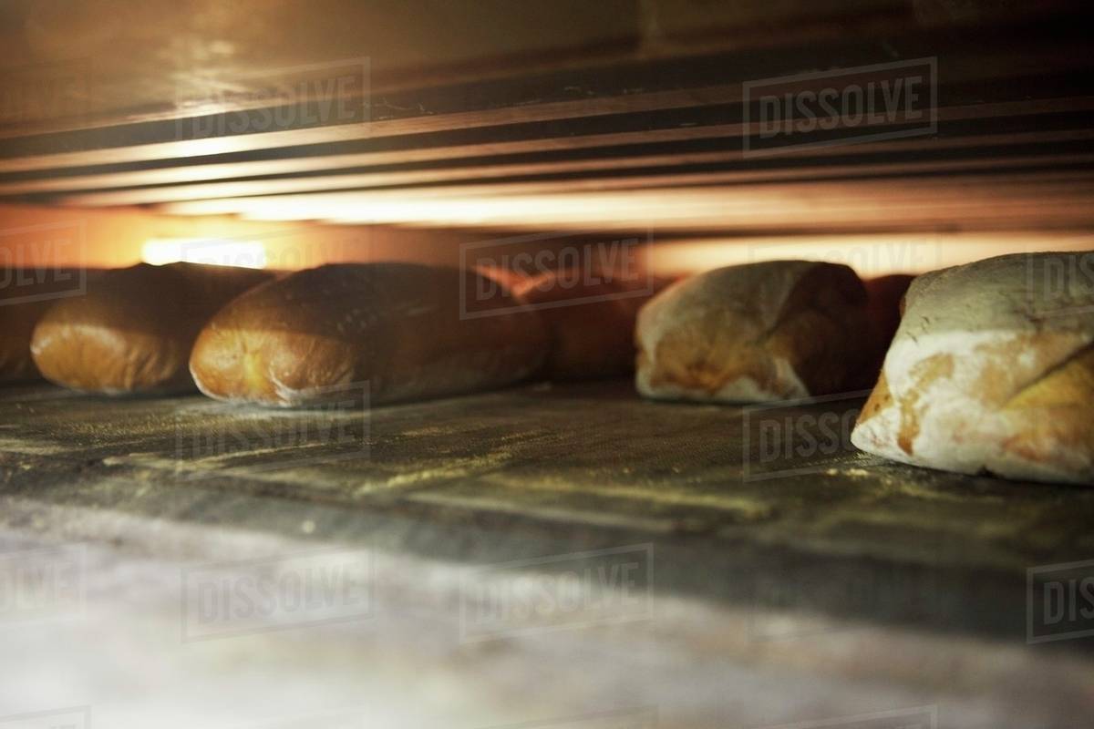 Various types of bread in an oven Stock Photo Dissolve