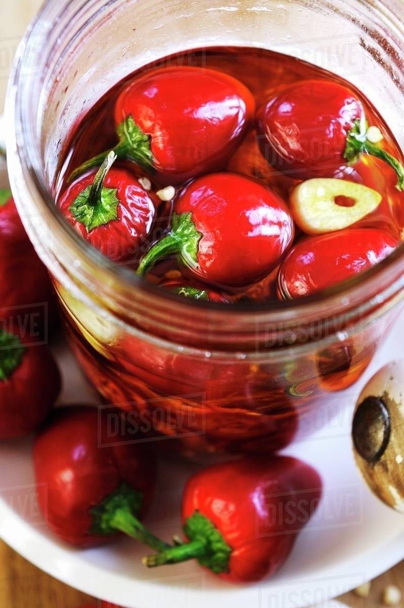 Peppers preserved in oil and garlic Stock Photo Dissolve