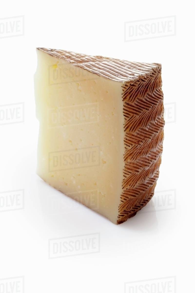 A slice of Manchego cheese Stock Photo Dissolve