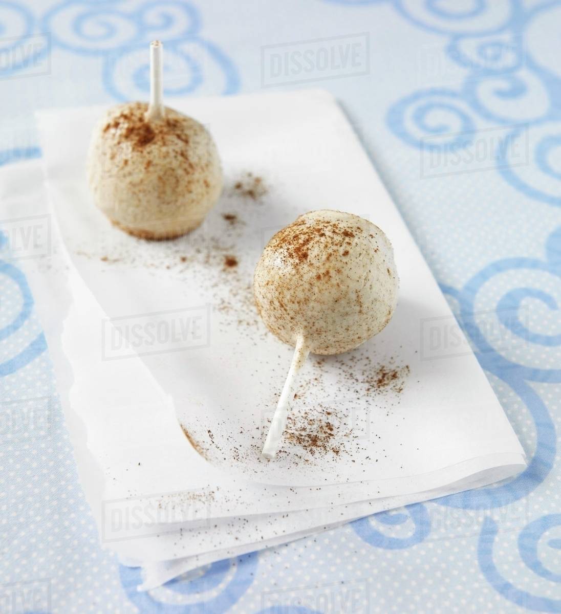 Two Cinnamon Cake Pops on Folded Paper Stock Photo Dissolve
