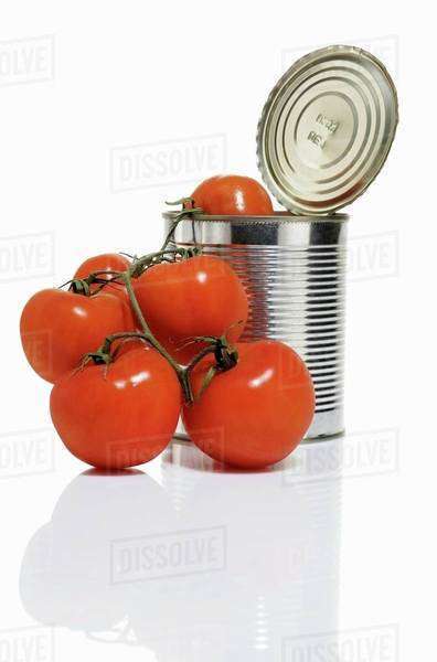 Opened tomato tin with fresh tomatoes - Stock Photo - Dissolve